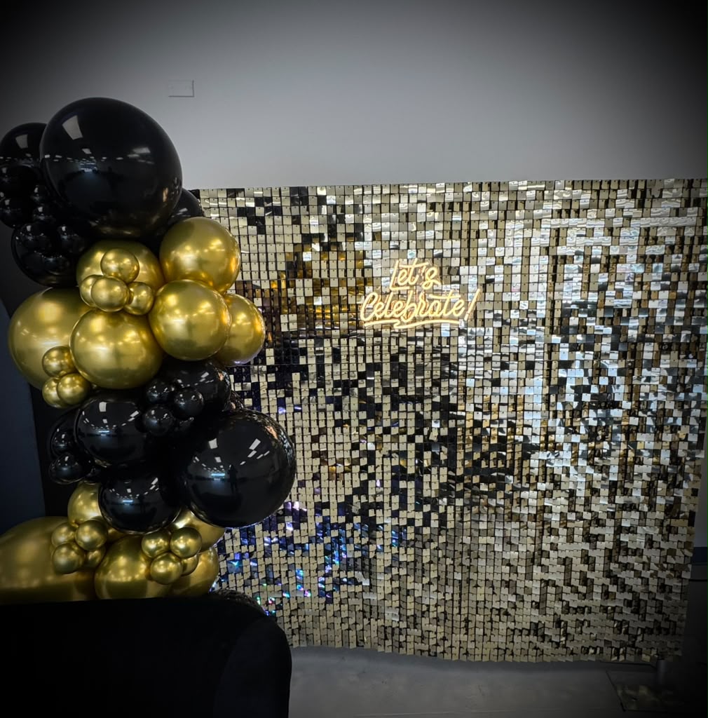 Gold sequin backdrop with black and gold balloons