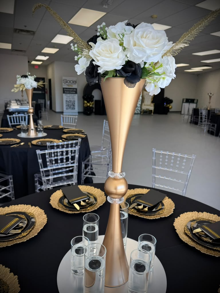 White floral centerpiece in a gold vase