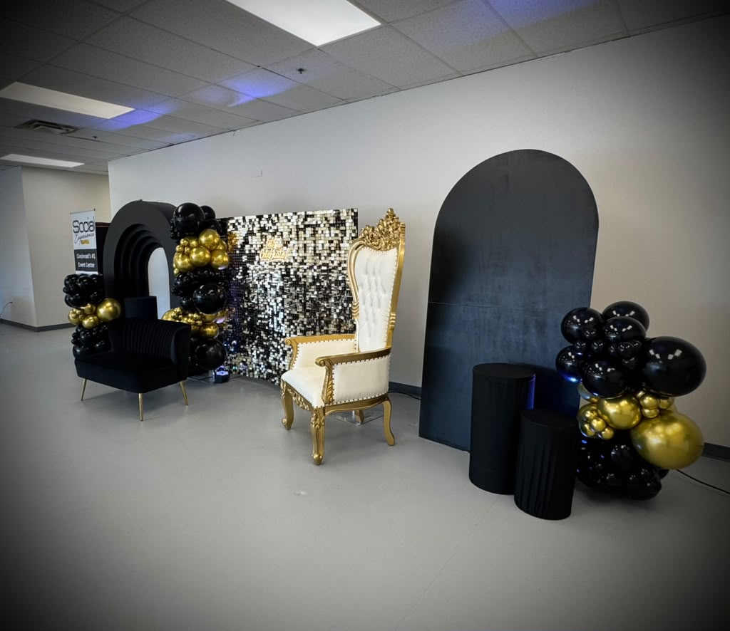 Celebration display with a gold throne chair and black arches